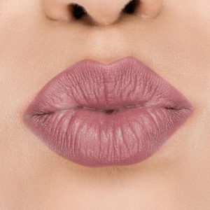 Raww - Coconut Kiss Lipstick in the shade of Fancy Fig with a closeup image applied to a woman's puckered lips