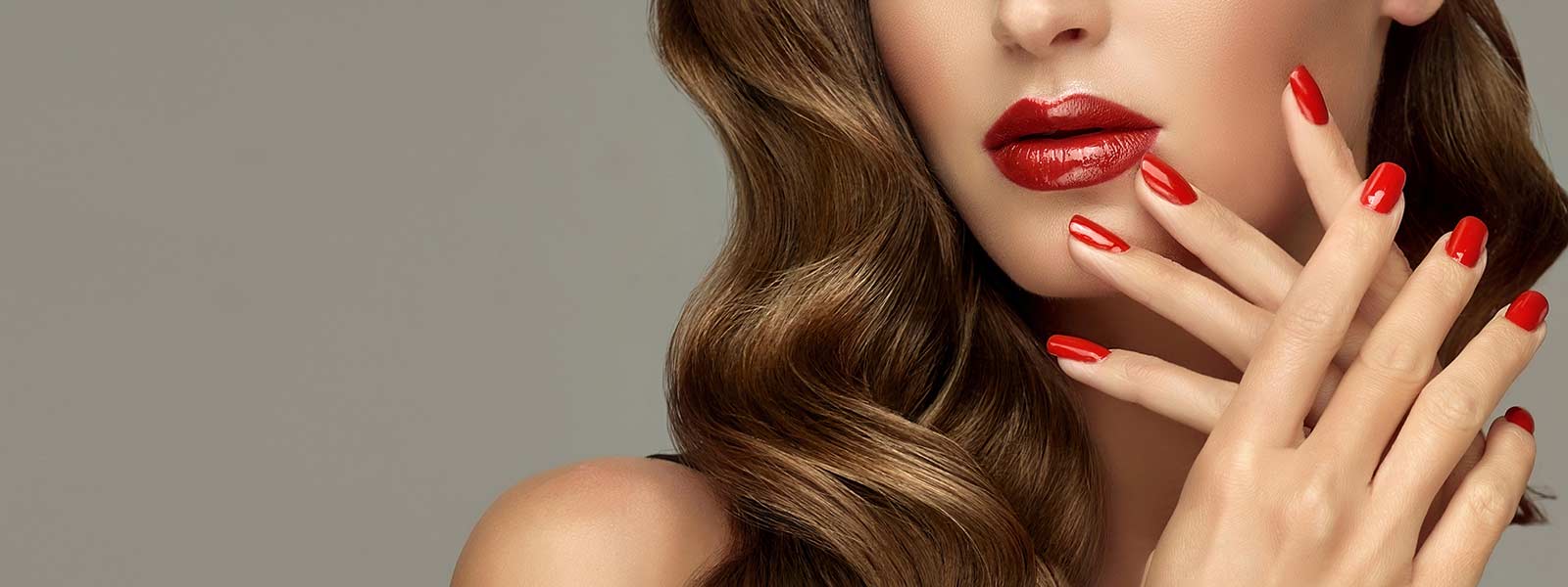 Woman with naturally beautiful wavy brown hair, matching red and nail coloour, with silky smooth healthy skin.