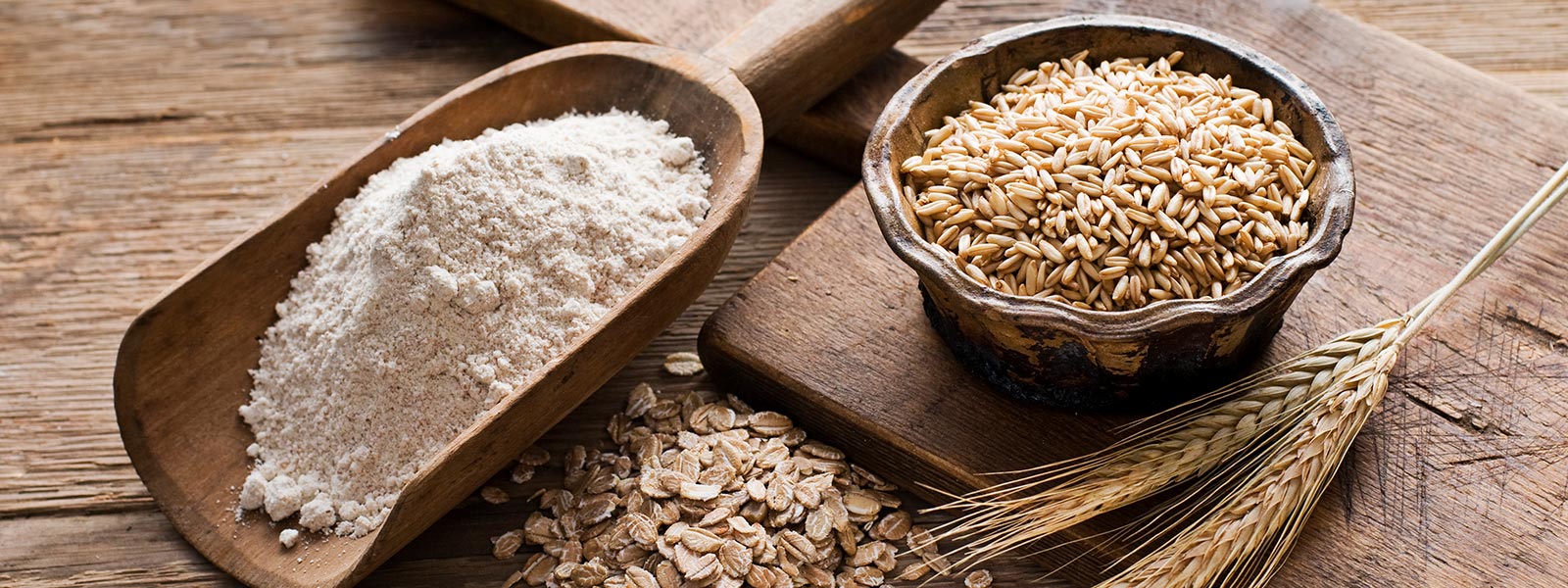 Organic and Natural Foods displayed on a wooden table with flour, grains, and oats