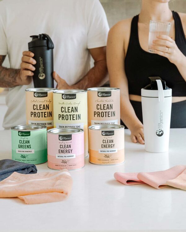 Man and woman standing by table with Nutra Organics Clean Active product range