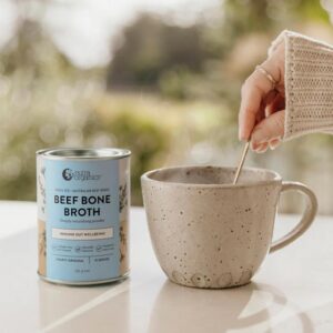 A stylized image of cup of hot Nutra Organics Beef Bone Broth alongside a 125g container of the product